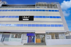 A multi-story building with a sign reading 'Collection' and a company-serviced logo.
