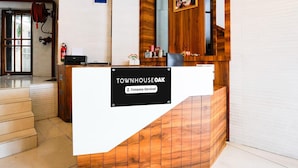 A reception desk with a sign reading "TOWNHOUSE OAK" and "Company Serviced". - Super Townhouse Oak Vashi (Navi Mumbai)