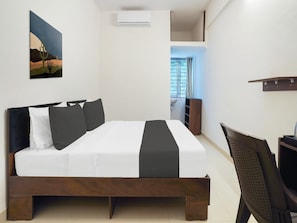 Ein Schlafzimmer mit Bett, Gemälde, Klimaanlage, Fenster und Schreibtisch.