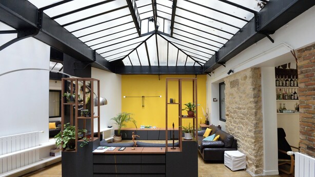 A modern interior with a central seating area, a wooden table, and a brick wall. - Beautiful 3-bedroom loft in the heart of Paris (Paris)