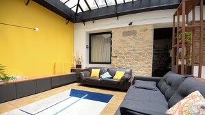 A living room with a sofa, a coffee table, a rug, and a bookshelf. - Beautiful 3-bedroom loft in the heart of Paris (Paris)