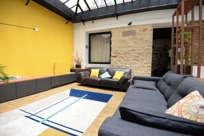 Ein Wohnzimmer mit einer Couch, einem Couchtisch, einem Teppich und einem Bücherregal.