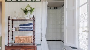 A bathroom with a wooden vanity, a shower curtain, and a window with decorative glass. - Villa Near Lucca With Tuscan Garden Views (Capannori)