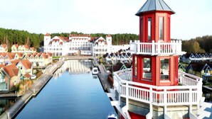 A canal with a red and white tower, surrounded by traditional houses and a large white building. - 4 Person Holiday Park Home in Grosszerlang (Rheinsberg)