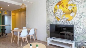 A modern living room with a dining area, a flat-screen TV on a stand, and a floral wallpaper. - Private Room in a Shared Apartment - Bron (Bron)