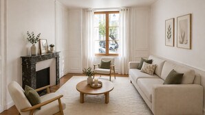 Uma sala de estar com lareira, sofá, poltrona, mesa de centro e uma janela com cortinas.