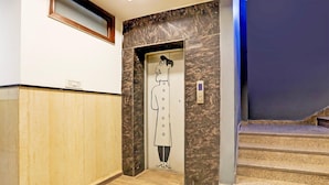 En elevator med en tegneseriefigur, trægulv og en marmorvæg.