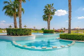 A swimming pool with palm trees, lounge chairs, and a clear sky. - 3BR Prestigia | Pool | Parking | 12min Centre (Marrakesh)
