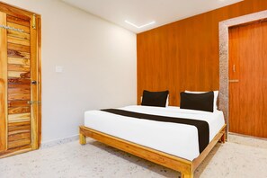 Ein Schlafzimmer mit einem hölzernen Bett, einem Holzschrank und einer Tür mit strukturierter Verkleidung.