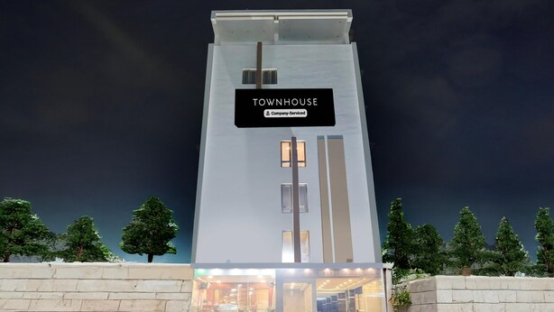 A modern townhouse with a prominent entrance, a visible staircase, and a sign indicating it is company-serviced. - Deluxe Sri Padmavati Ammavaari Temple Rama Grand (Tirupati)