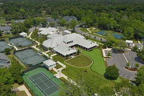 An aerial view of a residential area with multiple tennis courts, a large building with a flat roof, and surrounding greenery. - Brighton 2001 – Oceanview Elegance (Myrtle Beach)