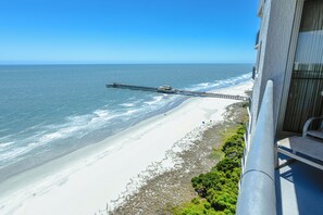 A beach view from a balcony with a pier extending into the ocean. - Brighton 2001 – Oceanview Elegance (Myrtle Beach)