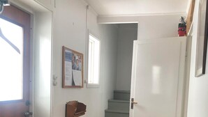 A hallway with a wooden bench, a staircase, and a door leading to another room. -  The Old Farmhouse (Hammarstrand)