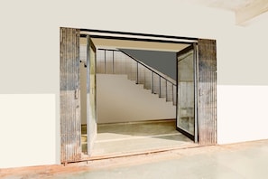 A staircase leading to an upper floor, a metal gate, and a tiled floor. - Deluxe Infocity Metrohotel Grand Krishna (Gandhinagar)