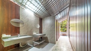 Un baño moderno con dos lavamanos, un espejo y una zona de ducha.