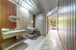 Une salle de bain moderne avec deux lavabos, un miroir et un espace douche.