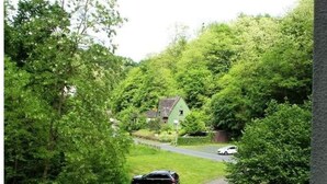 A parking area with multiple cars, a driveway leading to a house, and lush greenery surrounding the property. - 2 Person Holiday Park Home in Bendorf (Bendorf)