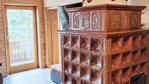 Un interior de madera con chimenea, una puerta con paneles de vidrio y un banco.