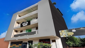 A modern hotel with a signboard, balconies, and a gated entrance. - Super Hotel O Dadri Main Greater Noida (Greater Noida)