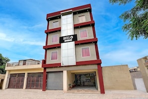 A multi-story hotel with a prominent sign, a gated entrance, and a balcony on the upper floor. - Classic With Balcony Pacify Hills (Dehradun)