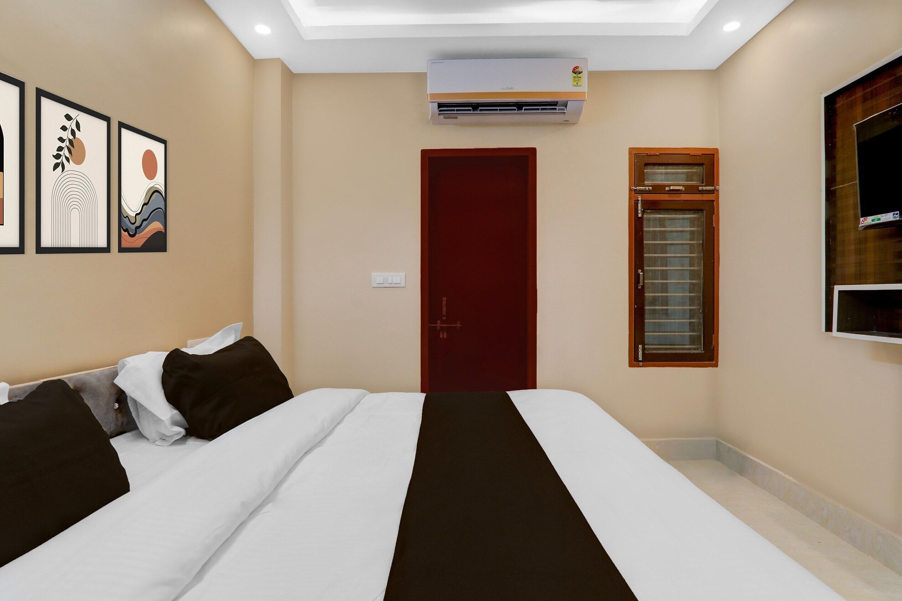 Een hotelkamer met een bed, een garderobe, een televisie en wanddecoratie.