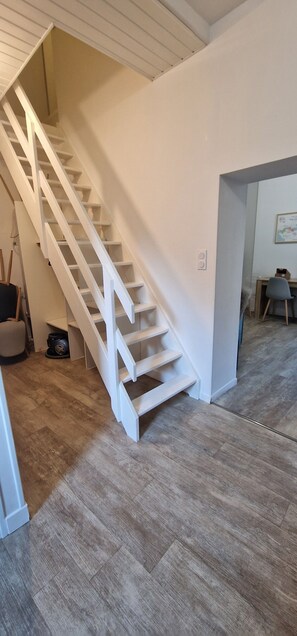 Eine Treppe mit weißen Geländern, die zu einer Empore führt.