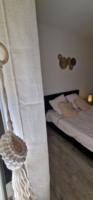 Ein Schlafzimmer mit einem Bett, einem Wandbehang aus Makramee und einer Wanddekoration.