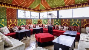 Una stanza con pareti decorate, un divano rosso, un tavolo nero e una finestra con vista.