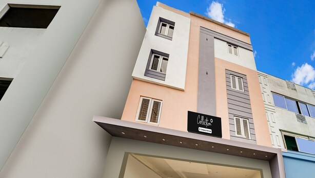A multi-story building with a flat facade, a sign indicating 'Collection & Company Services,' and a clear sky in the background. - Collection O RS Puram North Railway (Coimbatore)