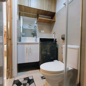 Ein Badezimmer mit Toilette, Waschbecken, Spiegel und Dusche.