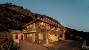 A stone house with a balcony, a driveway, and a view of the surrounding hills. - Borgo Corbaro - Exclusive Retreat  (Forio)