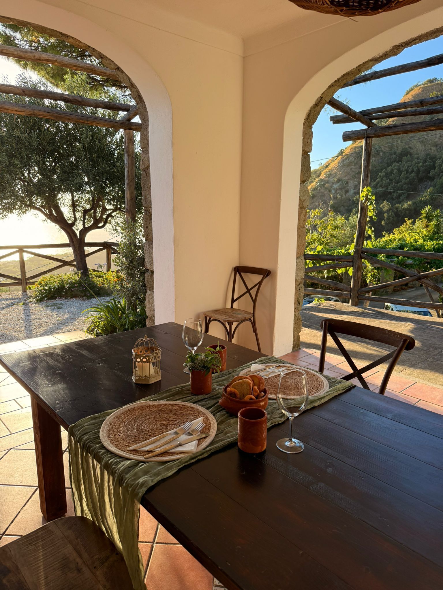 A dining table set outdoors with a view of a mountainous landscape.