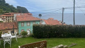 Ein Wohngebiet mit Häusern, einer Bank und Blick auf das Meer.