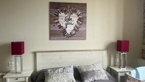 Ein Schlafzimmer mit einem Bett, zwei Nachttischen, einem Kopfteil und einer Wanddekoration.