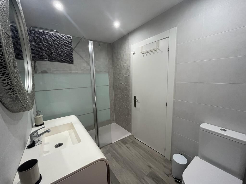 A bathroom with a shower, toilet, and sink.
