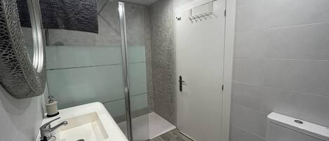 Ein Badezimmer mit Dusche, Toilette und Waschbecken.