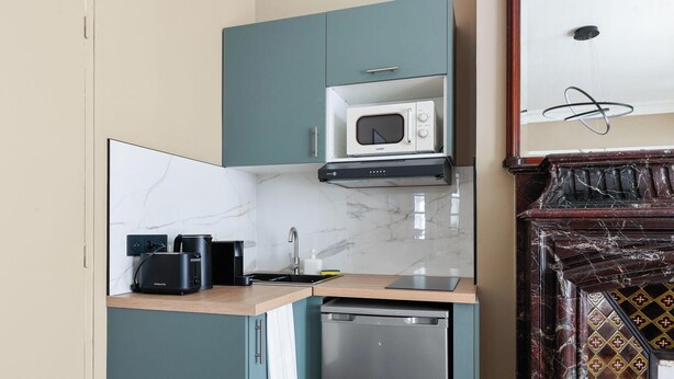 A compact kitchen with a microwave, toaster, and dishwasher. - Prestige appartement à Paris (Paris)