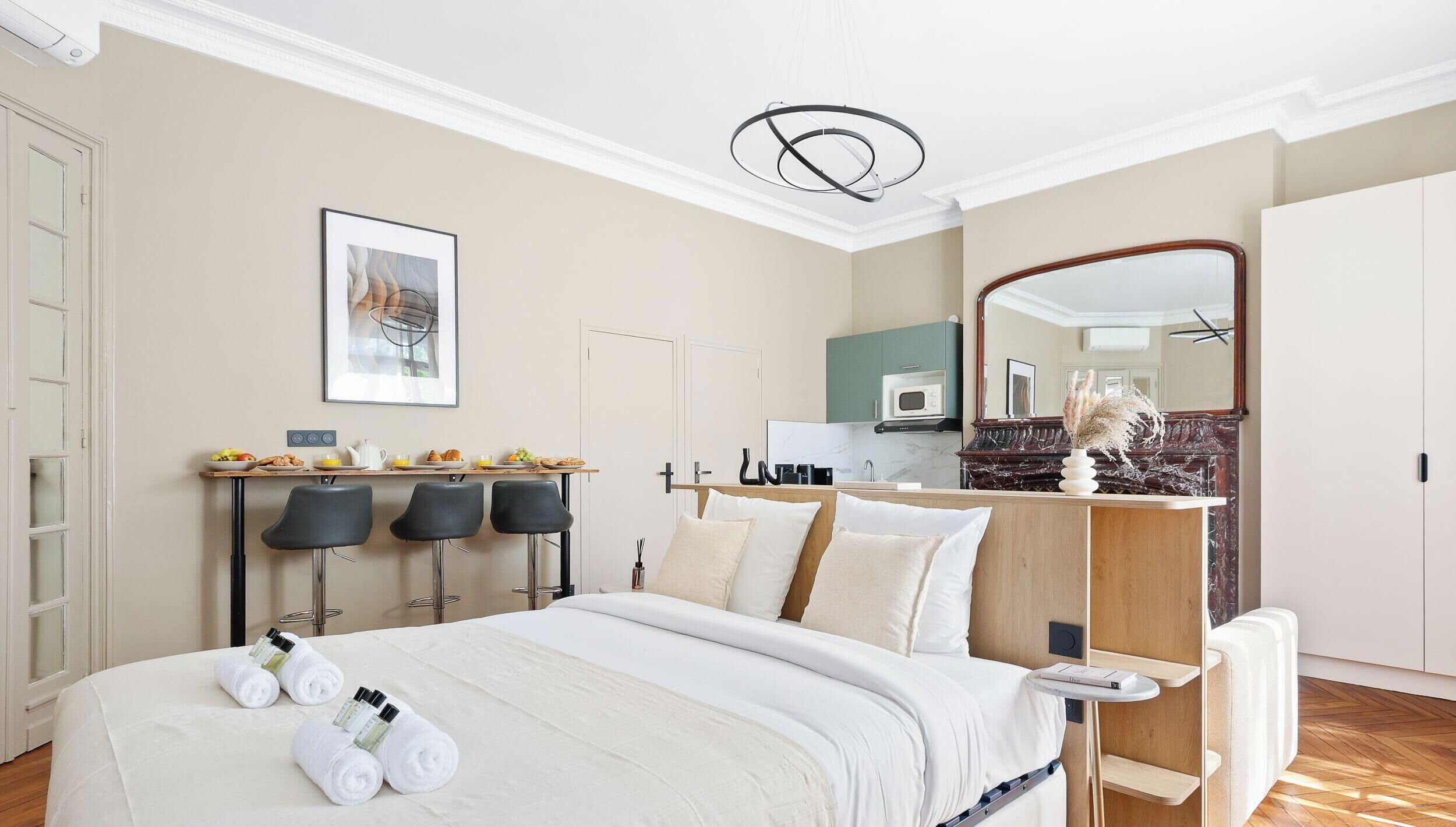 Une chambre d’hôtel équipée d’un lit, d’un coin petit-déjeuner, d’un four à micro-ondes et d’un grand miroir.