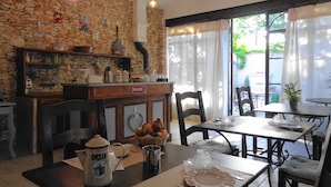Ein gemütliches Café mit Steinwänden, Holzmöbeln und Blick ins Freie.