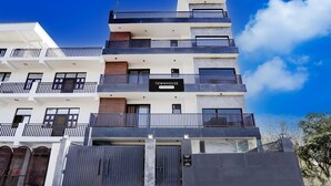 Useita kerroksia sisältävä rakennus, jossa on parvekkeita, ja sen yläpuolella on kyltti, jossa lukee ”TOWNHOUSE”, sekä portilla varustettu sisäänkäynti.