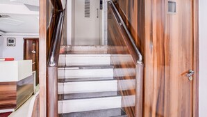 Una escalera con barandillas de metal, una puerta de madera y un cartel con texto.