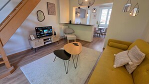 A modern living room with a sofa, a coffee table, a TV, and a staircase. - Perchoir d Augustin Arras Calme Centre (Arras)