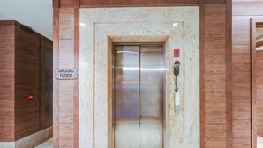 An elevator with a 'GROUND FLOOR' sign, a red emergency button, and a keypad on the wall. - Saver Doublekey Rooms (New Delhi)