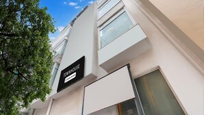 A building with a sign reading 'TOWNHOUSE' and a window with a view of the sky. - Saver Doublekey Rooms (New Delhi)