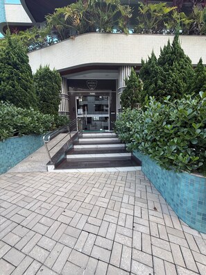 A hotel entrance with a tiled facade, a sign reading 'Beverly Hills Residence,' and a staircase leading to the entrance. - Exclusive apartment 50 meters from the sea (Bombinhas)