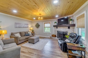 A living room with a fireplace, a TV, and a wooden ceiling. - Covered Patio, Fire Pit & Grills: Olmstead Getaway (Elkton)