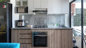 Cozinha moderna com forno embutido, micro-ondas e cafeteira.