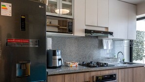 Uma cozinha moderna com frigorífico embutido, fogão, forno e bancada de granito.