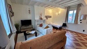 Una sala de estar moderna con sofá, televisor, chimenea y cama.