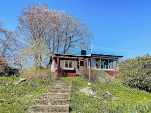 A house with a red exterior, a porch, and a staircase leading up to the entrance. - 5 Person Holiday Home in Ronneby (Ronneby)